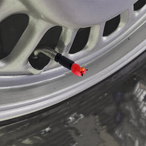 Devil duck valve stem cap installed on a car tire valve at an angled view – Xalvoria