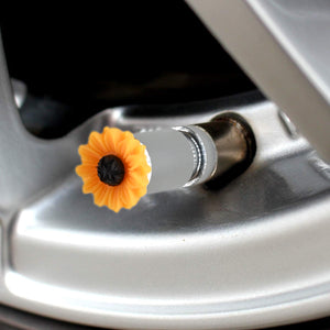 Sunflower valve stem cap installed on a car rim, bright floral tire accessory for decorative wheels