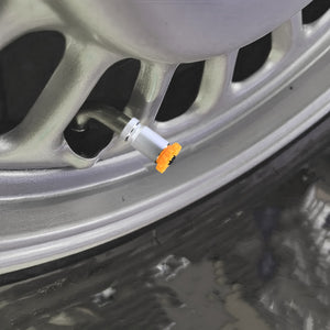 Sunflower valve stem cap installed on a car rim, decorative tire accessory with bright floral design