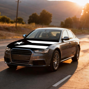 Xalvoria black and white Puerto Rico flag car hood cover on sedan driving on a sunset road