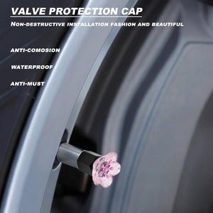 Xalvoria pink cherry blossom valve stem cap shown installed on a wheel valve with waterproof and anti-corrosion features.