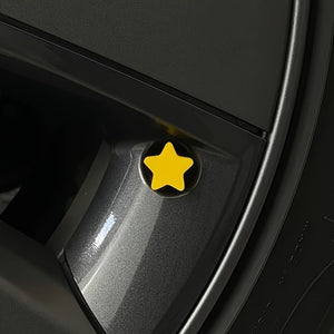 Close-up view of the yellow star valve stem cap installed on a car wheel, highlighting the bright decorative design.