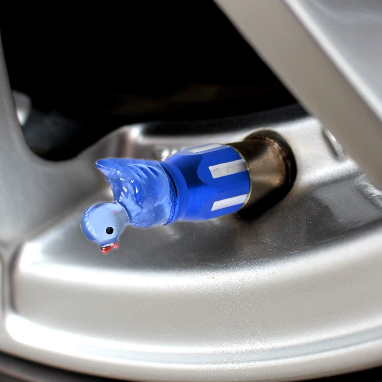 Blue duck valve stem cap installed on a car wheel, cute decorative tire accessory by Xalvoria.