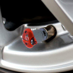Close-up view of the ladybug valve stem cap installed on a car tire valve – Xalvoria
