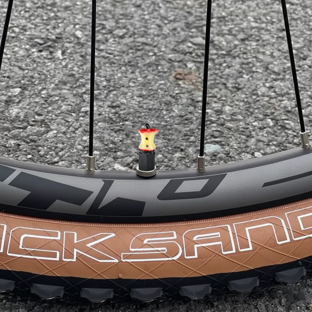 Xalvoria Apple Core valve stem cap installed on bicycle wheel outdoors
