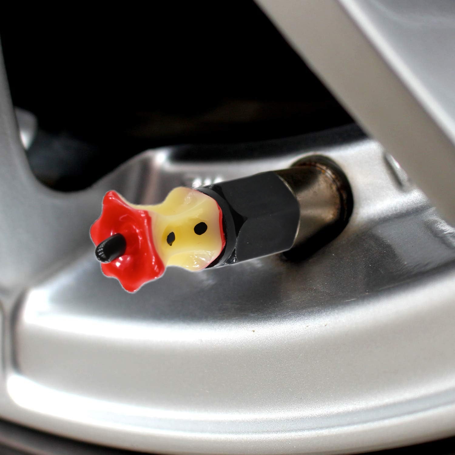 Xalvoria Apple Core valve stem cap installed on silver car wheel close-up