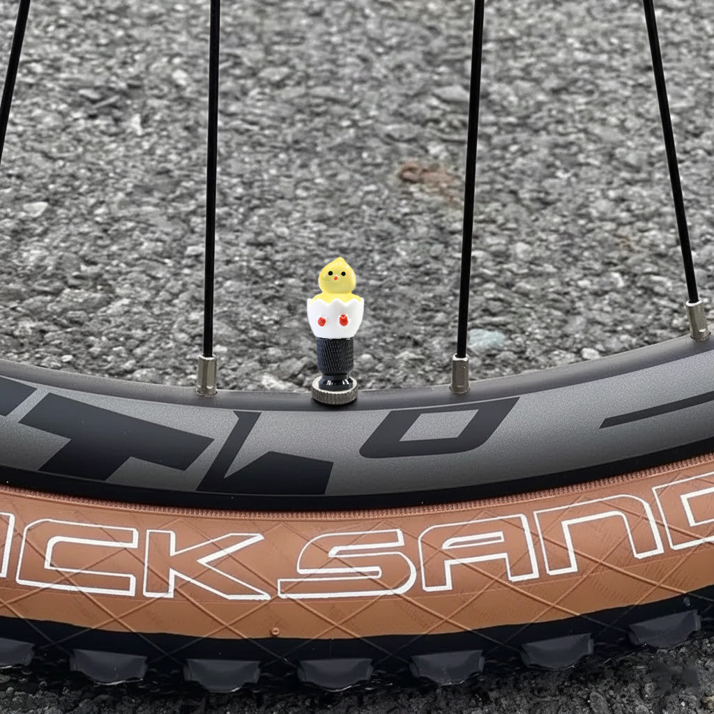 Xalvoria Black Base Yellow Eggshell Chicken valve stem cap installed on a bicycle wheel