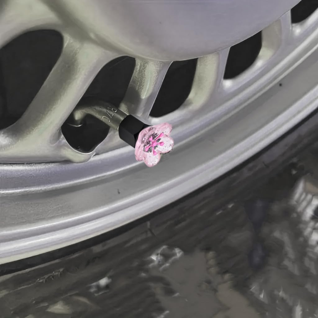 Xalvoria pink cherry blossom valve stem cap shown installed on a car wheel valve in a close-up scene.