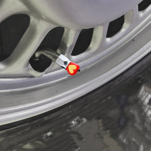 Xalvoria red Apple Core valve stem cap installed on a car rim adding a decorative apple accent to the wheel.