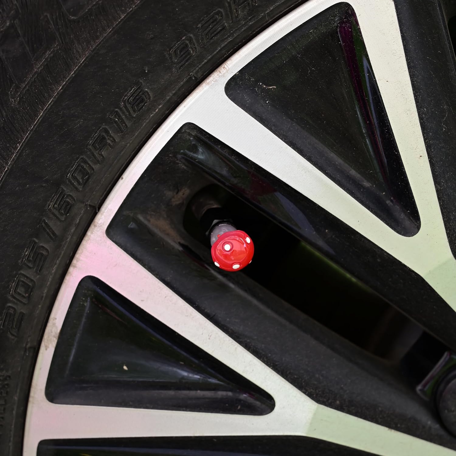 Xalvoria red Mushroom valve stem cap installed on car wheel valve stem.