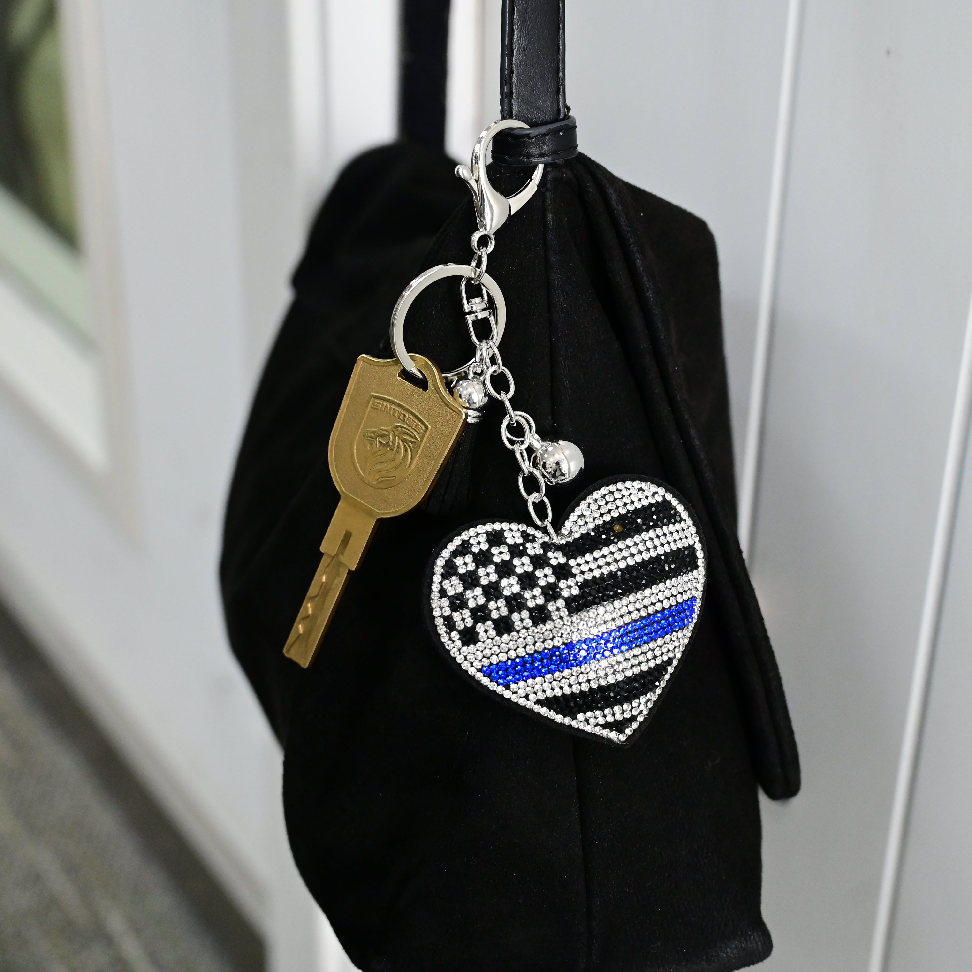 Xalvoria rhinestone Thin Blue Line heart keychain hanging on black handbag as decorative charm