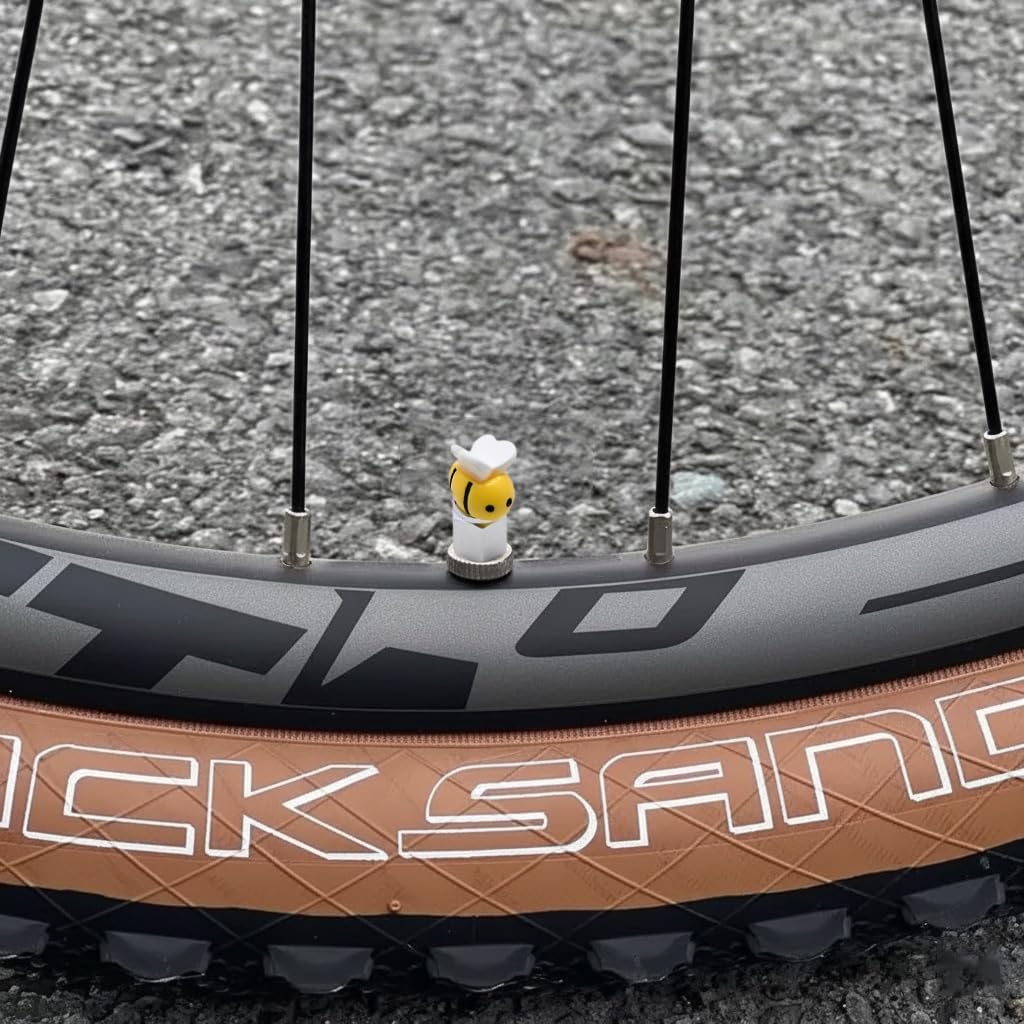 Xalvoria yellow bee valve stem cap attached to a bicycle tire valve, adding a fun and playful detail to the bike.