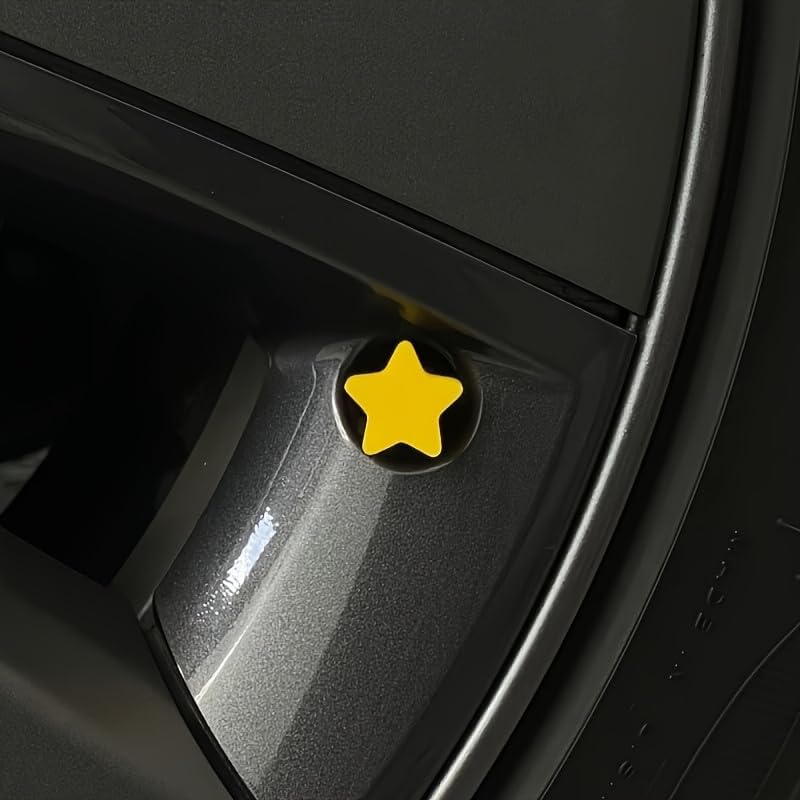 Close-up view of the yellow star valve stem cap installed on a car wheel, highlighting the bright decorative design.